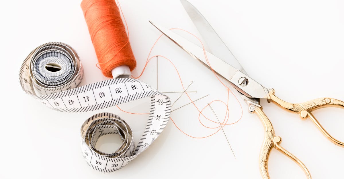 Photo of sewing essentials: scissors, thread, needles, and tape measure on a white background.